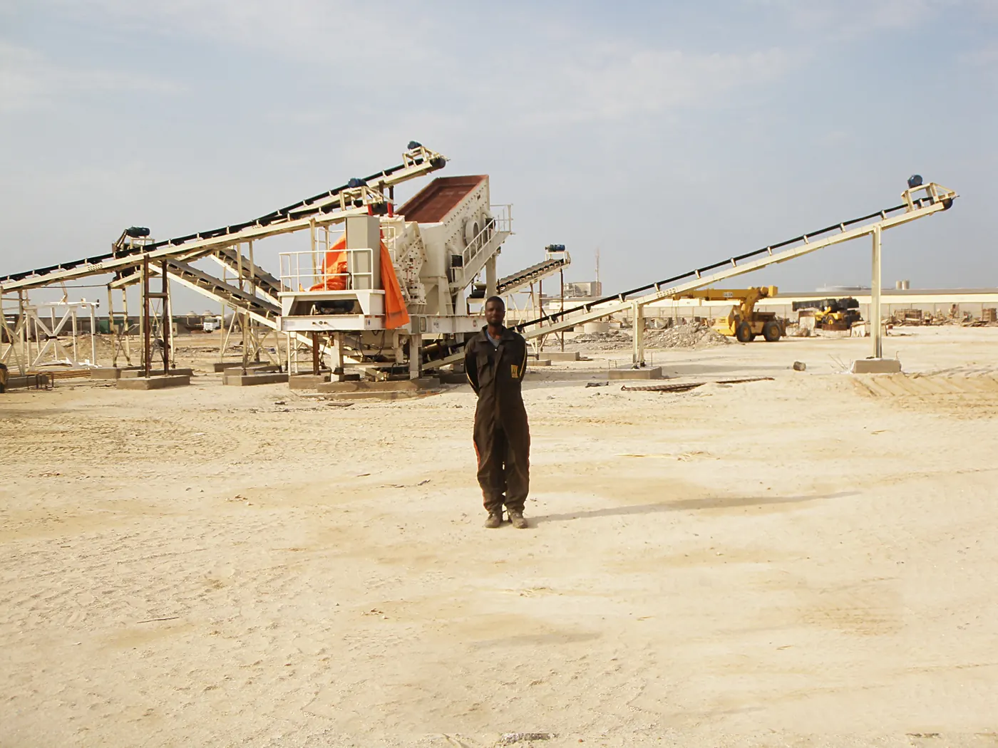 Wheeled portable crushing station feeding crushed rock to stockpile at an open pit mine